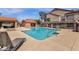 Community pool featuring tiled edging, a lounge chair and well-maintained landscaping against a blue sky backdrop at 609 E Mesquite Cir # D132, Tempe, AZ 85288