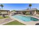Inviting backyard oasis featuring a sparkling pool, covered patio, and built-in bar for ultimate outdoor enjoyment at 6605 W Altadena Ave, Glendale, AZ 85304