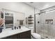 Updated bathroom with dark vanity, quartz countertop, walk-in shower with rainfall shower head, and neutral tile at 6605 W Altadena Ave, Glendale, AZ 85304