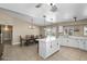 Bright open kitchen features a center island, white cabinets, and view of the dining area and backyard pool at 6605 W Altadena Ave, Glendale, AZ 85304