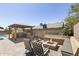 Entertain in style with a full outdoor kitchen, fire pit, and seating area surrounded by lush greenery at 6605 W Altadena Ave, Glendale, AZ 85304