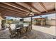 Outdoor living space with a pergola-covered dining area, an outdoor kitchen, and a view of the sparkling pool at 6605 W Altadena Ave, Glendale, AZ 85304