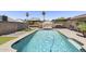 Sparkling pool with patio dining, outdoor kitchen, and well-manicured landscaping in the backyard at 6605 W Altadena Ave, Glendale, AZ 85304
