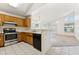 Bright kitchen with a view of the living room featuring wooden cabinets and stainless steel appliances at 6719 W Sack Dr, Glendale, AZ 85308
