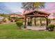 The backyard features a pergola with chairs, manicured lawn, and mature trees, perfect for relaxing and entertaining at 6861 W Calle Lejos --, Peoria, AZ 85383