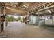 Spacious barn interior featuring a horse, brick flooring, ample lighting, and well-maintained stalls at 6861 W Calle Lejos --, Peoria, AZ 85383