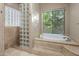 Bright bathroom featuring a garden tub, glass block shower, and natural light at 6861 W Calle Lejos --, Peoria, AZ 85383