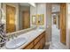 Bright bathroom with a double sink vanity, a mirror, wood cabinets, and a connecting hallway for added convenience at 6861 W Calle Lejos --, Peoria, AZ 85383
