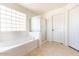 Bathroom with a bathtub, tile floor, glass block window, and a shower at 7102 W Pueblo Ave, Phoenix, AZ 85043