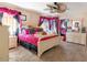 Bedroom with pink bedding, a ceiling fan, and a window with pink and black curtains at 7102 W Pueblo Ave, Phoenix, AZ 85043
