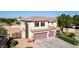 An elevated angle showing a two-story home with a three-car garage, desert landscaping and grass at 7102 W Pueblo Ave, Phoenix, AZ 85043