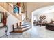 Open-concept layout with tile flooring, a staircase, and a comfortable living room at 7102 W Pueblo Ave, Phoenix, AZ 85043