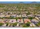 Aerial view of a desert home showcasing tile roof, desert landscaping, and mountain views in a vibrant community at 7710 E Tardes Dr, Scottsdale, AZ 85255