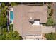 Aerial view of a desert home showcasing tile roof, backyard pool, landscaping and circular tower feature at 7710 E Tardes Dr, Scottsdale, AZ 85255