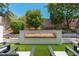 Backyard with a modern linear fireplace and chairs on artificial grass at 7710 E Tardes Dr, Scottsdale, AZ 85255