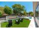 Large backyard featuring a modern fireplace, chairs and a sparkling pool at 7710 E Tardes Dr, Scottsdale, AZ 85255