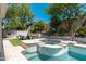 Resort-style backyard with a pool, spa, fire pit, and outdoor kitchen area perfect for entertaining at 7710 E Tardes Dr, Scottsdale, AZ 85255