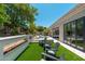 Expansive backyard featuring a pool, fireplace, chairs and lush greenery at 7710 E Tardes Dr, Scottsdale, AZ 85255