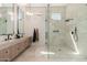 Bright bathroom features a double vanity with stone countertop and a glass enclosed shower with tile surround at 7710 E Tardes Dr, Scottsdale, AZ 85255