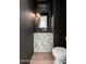 Striking powder room featuring a marble countertop sink, dark walls and pendant lighting at 7710 E Tardes Dr, Scottsdale, AZ 85255