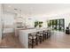 Bright, open kitchen featuring a large island, white cabinets, and modern lighting fixtures at 7710 E Tardes Dr, Scottsdale, AZ 85255