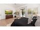 Main bedroom with black and white bedding, wooden dresser, tv, and patio access at 7710 E Tardes Dr, Scottsdale, AZ 85255