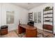 Bright home office with a dark wood desk, shelving and dual windows at 7710 E Tardes Dr, Scottsdale, AZ 85255