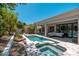 Backyard oasis with a sparkling pool, jacuzzi, covered patio, and comfortable outdoor furniture at 7710 E Tardes Dr, Scottsdale, AZ 85255