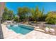 A backyard featuring a refreshing pool and desert landscaping under a clear blue sky at 7710 E Tardes Dr, Scottsdale, AZ 85255