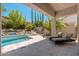 Inviting backyard featuring a pool, desert landscaping, and a covered patio with lounge seating at 7710 E Tardes Dr, Scottsdale, AZ 85255