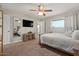 Comfortable bedroom with ceiling fan, TV, mirror, and natural light at 818 N Terrace St, Mesa, AZ 85203