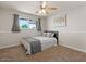 Bright bedroom with a ceiling fan, carpeted floors, and large window with neutral curtains at 818 N Terrace St, Mesa, AZ 85203
