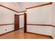 This room has white walls with wood trim, wood flooring and doors to other rooms and closets at 8606 S Dorsey Ln, Tempe, AZ 85284