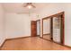 Bedroom with laminate flooring, ceiling fan, and closet with sliding mirrored doors at 8606 S Dorsey Ln, Tempe, AZ 85284