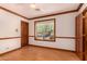 This bright bedroom has wood trim, wood floors, a ceiling fan, and a window view of a green leafy tree at 8606 S Dorsey Ln, Tempe, AZ 85284
