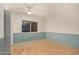 This bedroom has wood flooring and blue painted accent walls with a view of a window at 8606 S Dorsey Ln, Tempe, AZ 85284