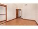 This bedroom features neutral walls, wood trim, and an open closet and door to another room at 8606 S Dorsey Ln, Tempe, AZ 85284