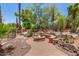 Backyard firepit area with built-in seating and lush desert landscaping, perfect for relaxing at 8606 S Dorsey Ln, Tempe, AZ 85284