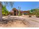 Stunning stone home with a beautiful arched entryway and desert landscaping with mature Saguaro cacti at 8606 S Dorsey Ln, Tempe, AZ 85284