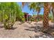 Desert home with an arched entryway, stone facade, tile roof, mature cacti, and professional landscaping at 8606 S Dorsey Ln, Tempe, AZ 85284