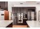 Kitchen featuring stainless steel appliances, island with quartz countertops, and dark cabinetry at 8606 S Dorsey Ln, Tempe, AZ 85284