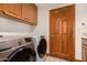 Laundry room featuring wood cabinets, tile floor, washer and dryer, and wood door at 8606 S Dorsey Ln, Tempe, AZ 85284