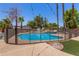 Sparkling backyard pool with safety fence, mature trees, and desert landscaping, perfect for relaxation at 8606 S Dorsey Ln, Tempe, AZ 85284
