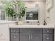 Bright bathroom with a modern vanity featuring gray cabinetry, updated fixtures, and ample counter space at 8803 N 105Th Dr, Peoria, AZ 85345