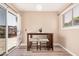 A cozy dining area features a small table, two stools, and sliding glass doors to the backyard at 8803 N 105Th Dr, Peoria, AZ 85345