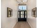 Welcoming foyer with wood floors, a decorative front door and modern artwork displayed at 9112 E Palm Tree Dr, Scottsdale, AZ 85255