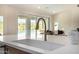 Kitchen sink with marble counter tops, view of living room, sliding glass doors and pool at 9112 E Palm Tree Dr, Scottsdale, AZ 85255