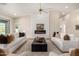Bright and airy living room featuring modern fireplace, ceiling fan, and white sofas at 9112 E Palm Tree Dr, Scottsdale, AZ 85255