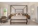 Cozy main bedroom with a canopy bed, sitting chair, and access to the ensuite bathroom at 9112 E Palm Tree Dr, Scottsdale, AZ 85255
