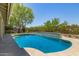 Inviting backyard pool featuring tile accents, mature trees, and a lush desert landscape at 9112 E Palm Tree Dr, Scottsdale, AZ 85255